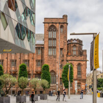 People gathered outside Manchester’s venues during a city event, with banners and architecture visible in the background